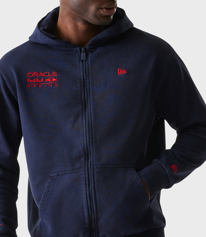 Close-up of a navy blue zip hoodie featuring Oracle Red Bull Racing embroidery on the left chest and a New Era logo on the right chest