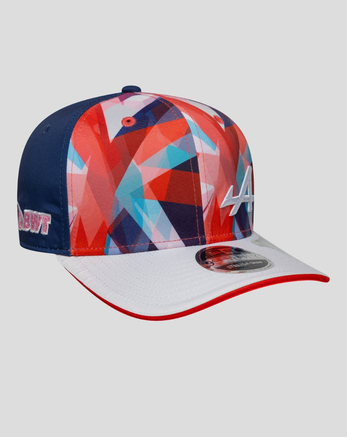Side view of the cap showing vibrant geometric crown pattern, blue side panel, white brim edge, and a white A logo on the front.