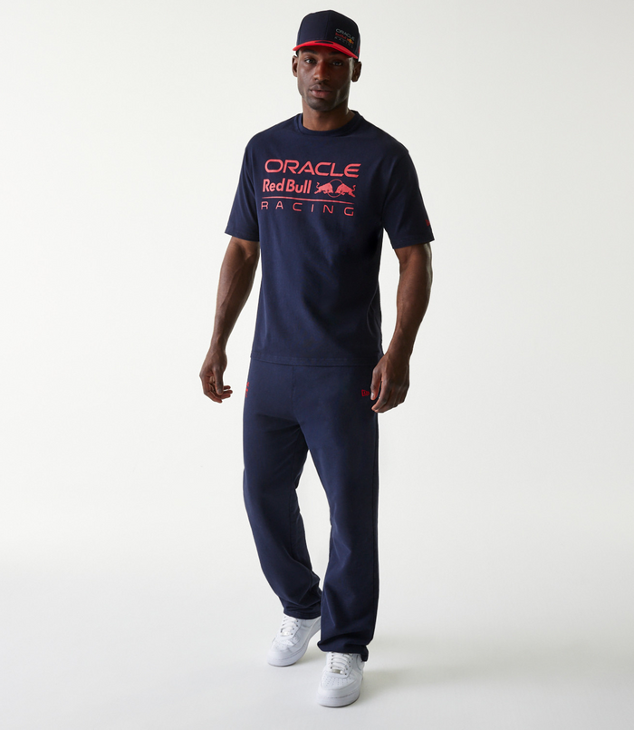 Front view of a man in a navy oversized Oracle Red Bull Racing t shirt and cap