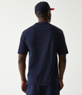 Back view of a man in a navy oversized Oracle Red Bull Racing t shirt and cap