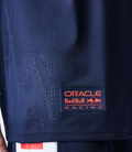 Male model wearing navy Oracle Red Bull Racing graphic oversized mesh t shirt with matching shorts and cap.