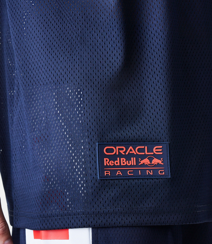 Male model wearing navy Oracle Red Bull Racing graphic oversized mesh t shirt with matching shorts and cap.