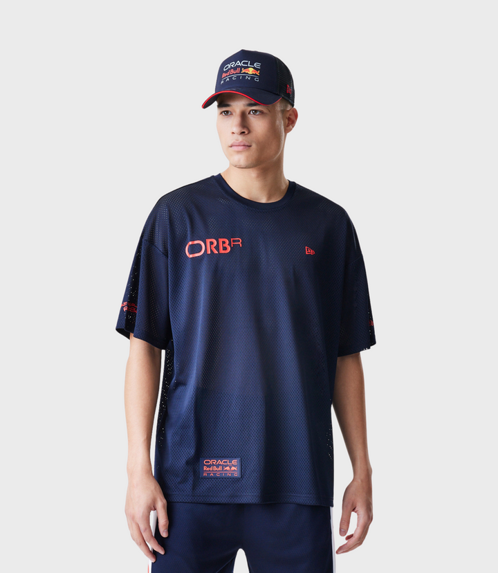 Male model in navy mesh t shirt with Oracle Red Bull Racing logo and hem patch wearing a cap