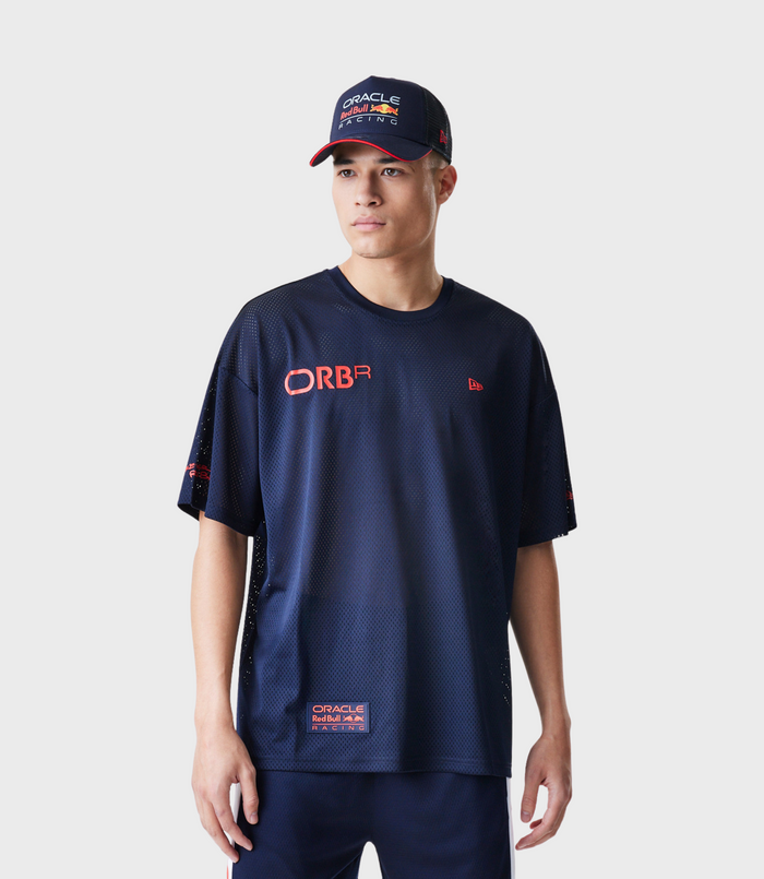 Male model in navy mesh t shirt with Oracle Red Bull Racing logo and hem patch wearing a cap