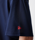 Close-up of dark blue mesh fabric from Oracle Red Bull Racing shirt showing perforated texture and a small red patch.