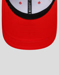 Red curved brim of a baseball cap with black edge and visible top stitching