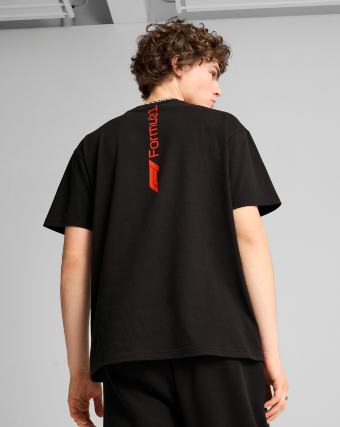 Back view of the black F1 Essential Relaxed Tee showing a vertical red Formula 1 graphic along the upper back.