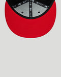 Red undervisor and brim of New Era Haas Team 9Fifty snap-back cap with black edge and branded interior tape.