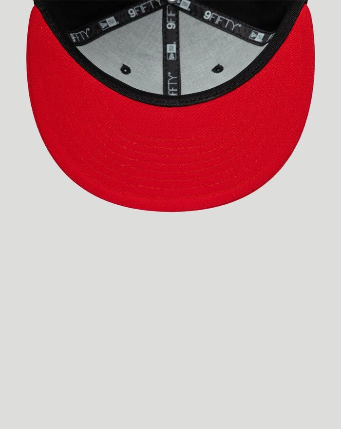 Red undervisor and brim of New Era Haas Team 9Fifty snap-back cap with black edge and branded interior tape.