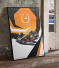 McLaren Formula 1 poster from the limited edition leaning at an angle near a window, featuring the orange hexagon and a racing car.