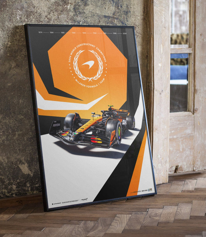 McLaren Formula 1 poster from the limited edition leaning at an angle near a window, featuring the orange hexagon and a racing car.