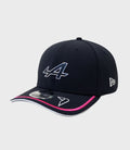 Navy New Era Alpine Rep Driver 9Seventy cap with pink trimmed brim and partial front logo