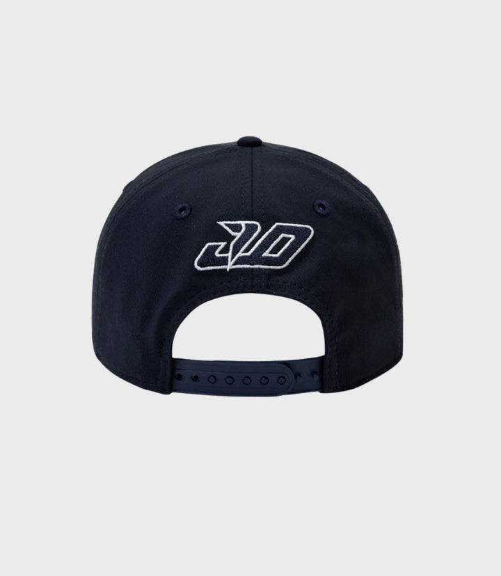 Front view of a navy New Era 9Seventy cap with a white embroidered logo on the crown
