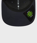 Close up of navy New Era 9Seventy cap brim with visible stitching and a neon green New Era sticker