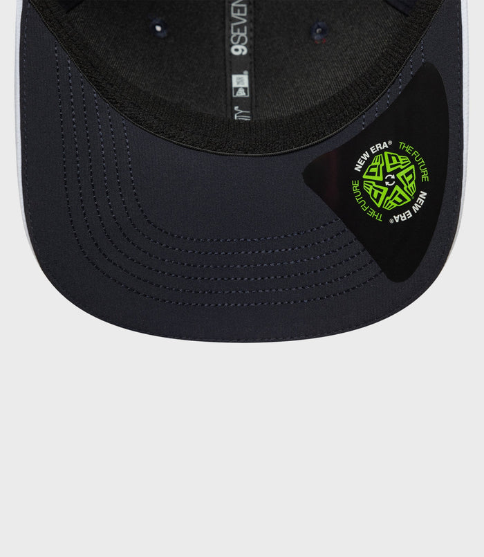 Close up of navy New Era 9Seventy cap brim with visible stitching and a neon green New Era sticker