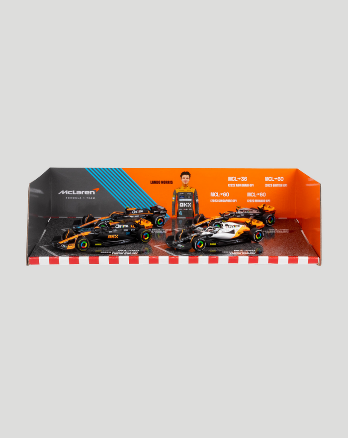 Two 1:43 McLaren F1 cars on a display tray with an orange backdrop and a driver cutout.