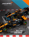 Two black and orange 1:43 McLaren F1 cars on a diorama track with McLaren branding.