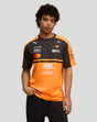 Front view of a male model wearing the McLaren Papaya 2026 Team T-Shirt with orange and black color blocks.