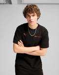 Male model wearing black F1 Essential Relaxed Tee with red Formula 1 branding and Puma logo.