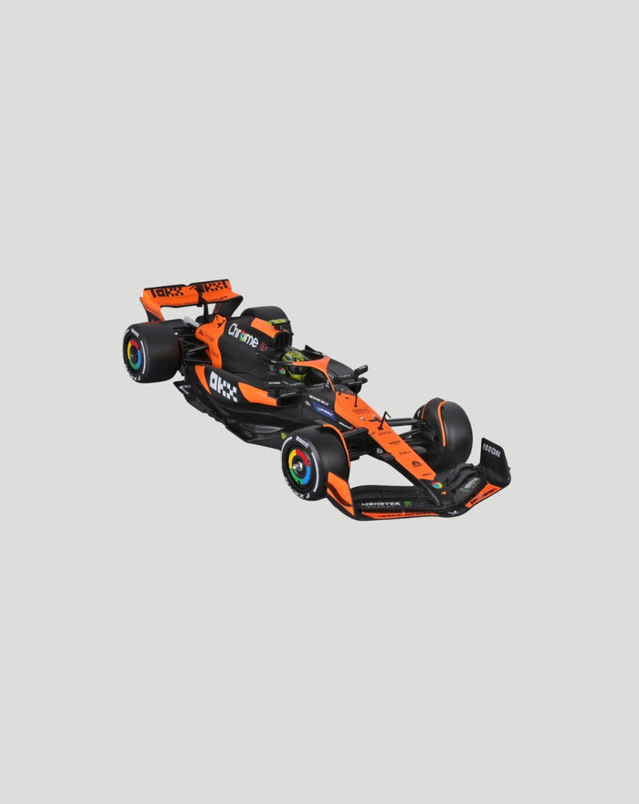 Angled side view of orange and black McLaren MCL38 1:24 scale model car on a light gray background