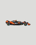 Side view of a 1:24 McLaren MCL38 2024 model car with Norris helmet in orange and black.