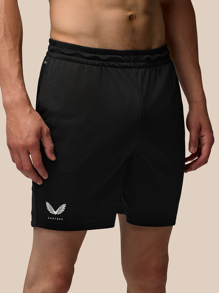 Close-up of black Adapt Training 7 Shorts showing elastic waistband and Castore logo on the hem