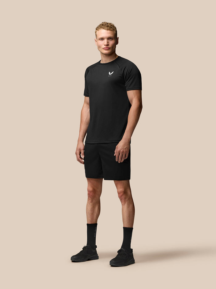 Full body front view of a male model in black Adapt Training 7 inch shorts.