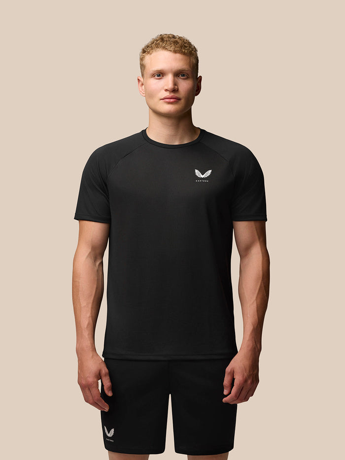 Male model wearing black Adapt Training T-Shirt front view with crew neck and raglan sleeves