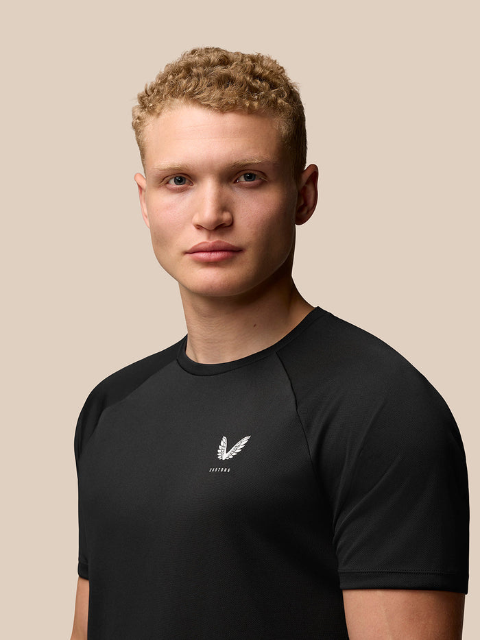 Portrait of a man wearing black Adapt Training T Shirt with Castore logo on the left chest