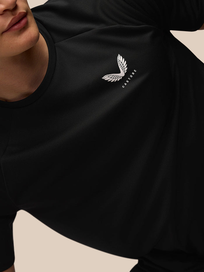 Close-up of black Adapt Training T-Shirt chest with white Castore wing logo