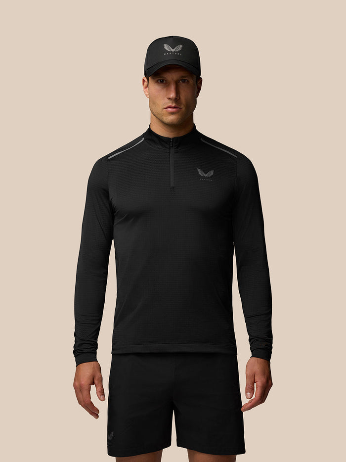 Front view of a man wearing the Apex Training 1/4 Zip Top in black with a stand collar and left chest branding.