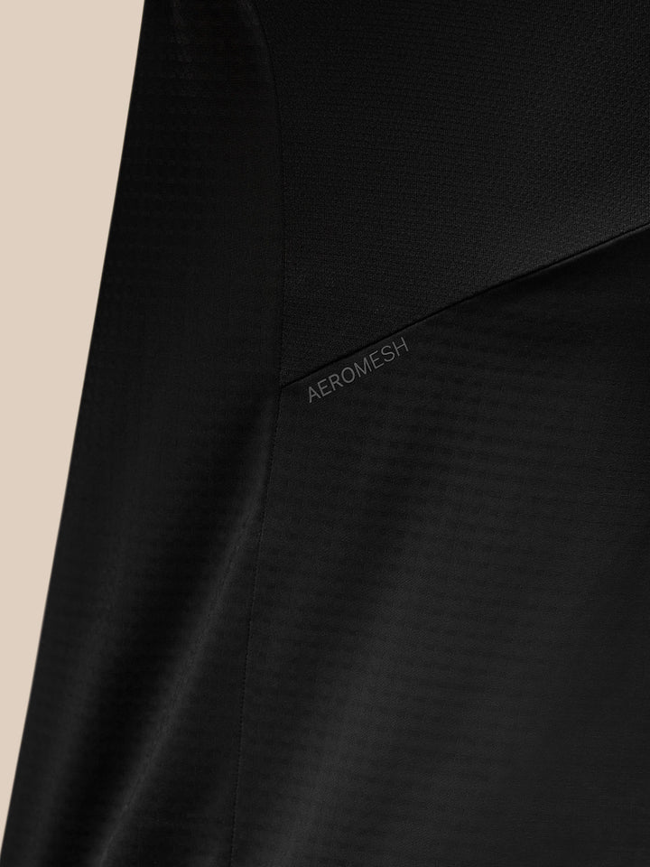 Back view of black Apex Training top showing Aeromesh panel at upper back and a reflective shoulder stripe