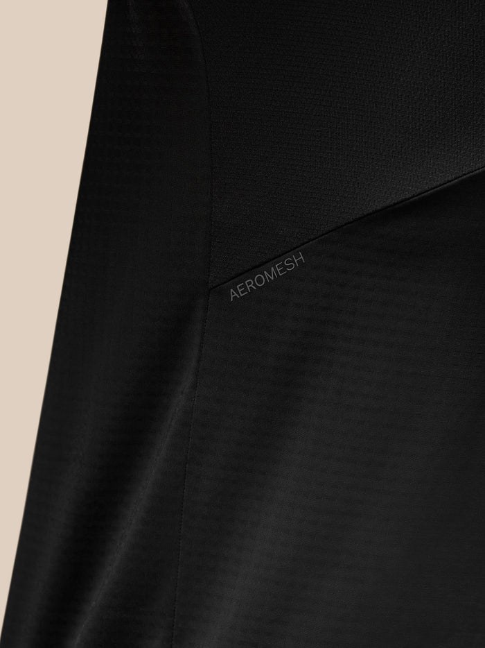 Back view of black Apex Training top showing Aeromesh panel at upper back and a reflective shoulder stripe