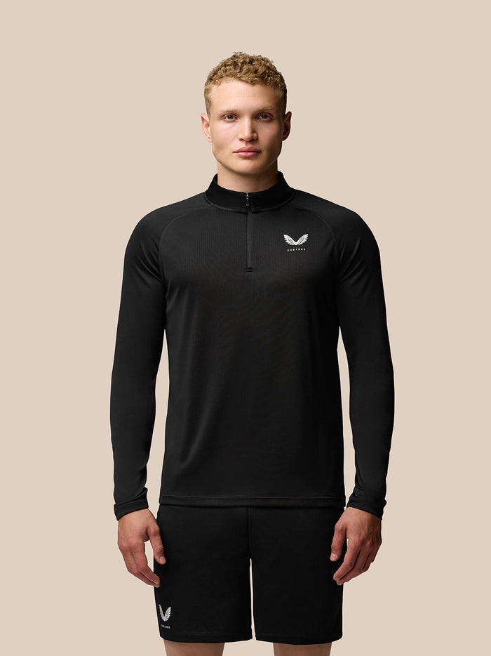Man wearing black Adapt Training 1/4 Zip Top with stand collar and front zip and Castore logo on the left chest