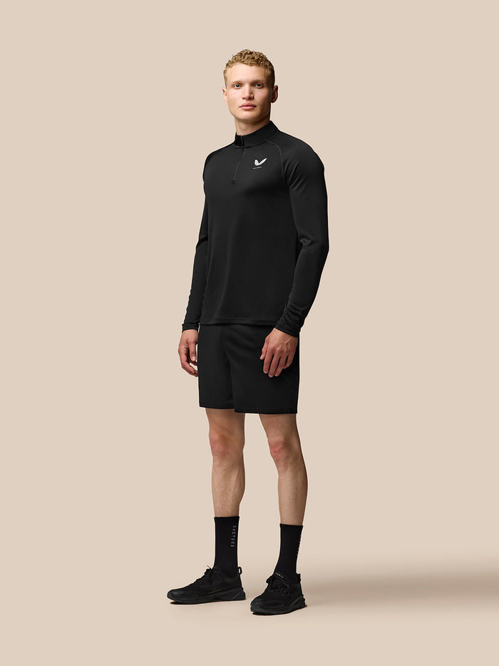 Male model wearing black Adapt Training 1/4 Zip Top with stand collar and left chest logo.