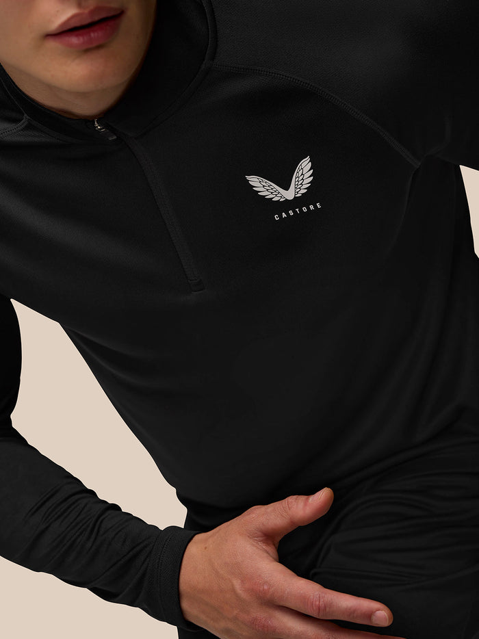 Back view of model in black Adapt Training 1/4 Zip Top showing Castore branding