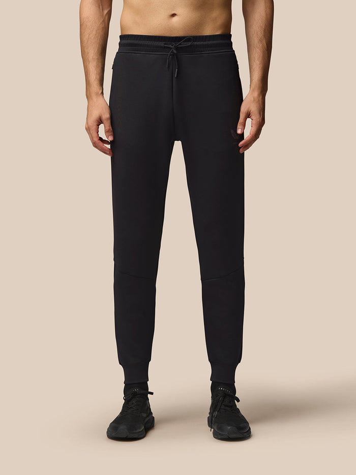Male model in black Flex Joggers with drawstring waist and Castore logo on left thigh