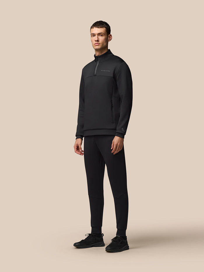 Full-body front view of a man wearing black Flex Joggers with a matching athletic top.