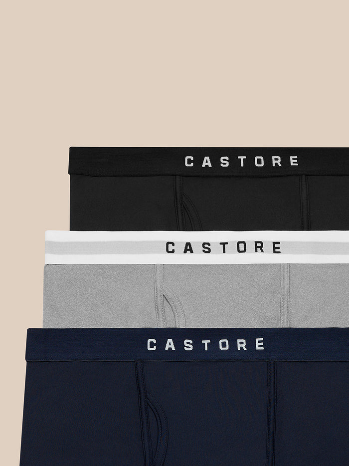 Three Castore Active boxer shorts stacked with branded elastic waistbands in black white gray and navy