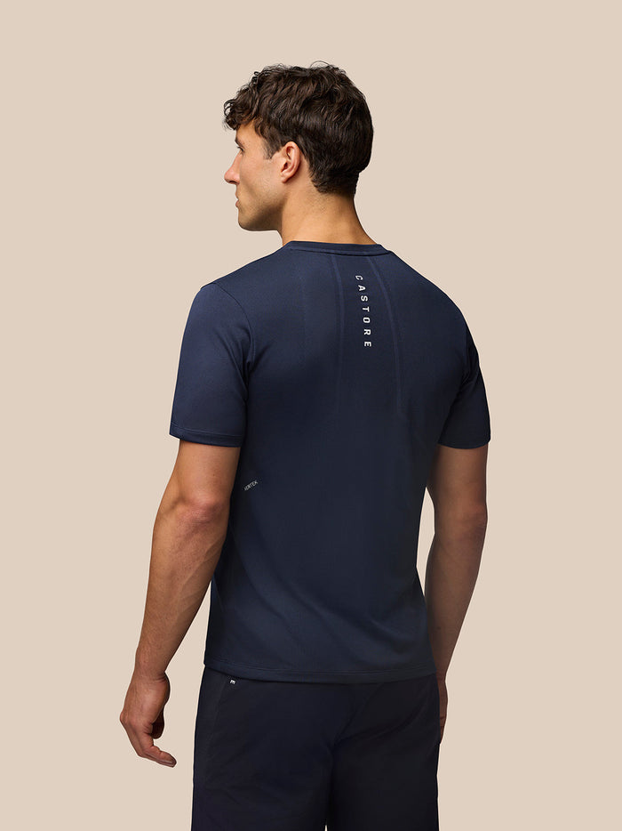 Back view of a male model in navy Apex Training T Shirt, showing vertical Castore branding along the upper back.