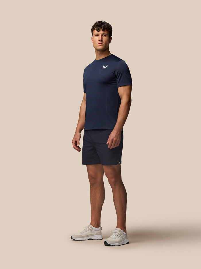 Male model in Midnight Navy Apex Training T Shirt with white left chest logo, full-body portrait