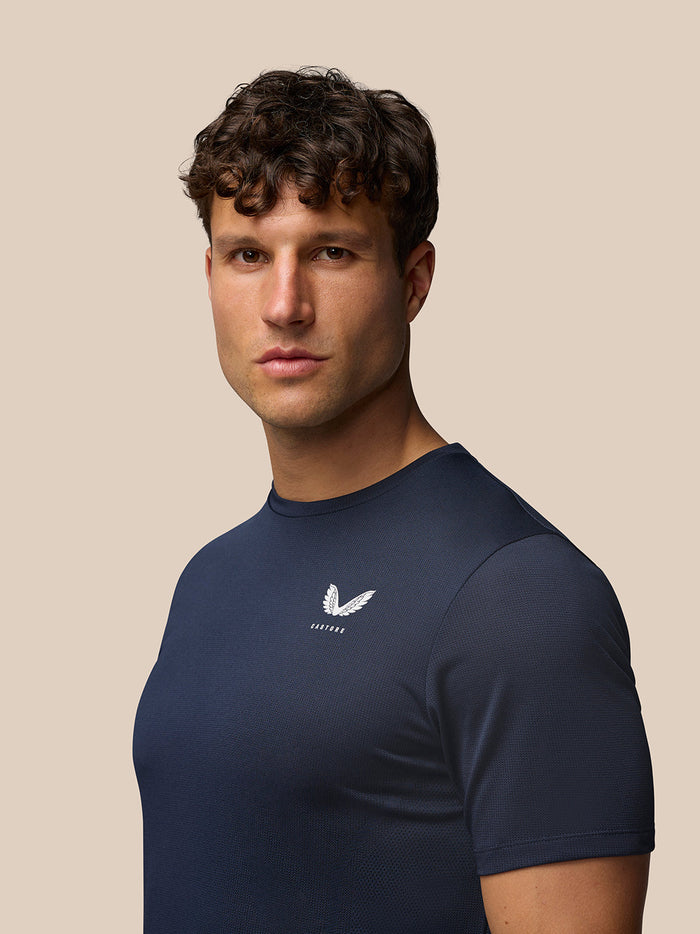 Male model wearing midnight navy Apex Training T Shirt with white left chest logo