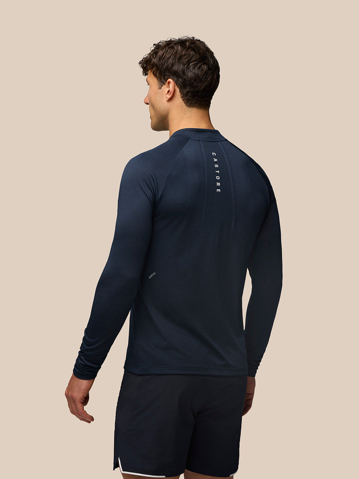 Back view of navy Apex Long Sleeve Engineered Knit Quarter Zip Top with vertical Castore branding along the spine