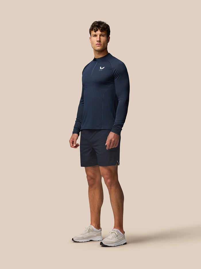 Male model wearing navy Apex Training 1/4 Zip Top with stand collar and left chest logo.