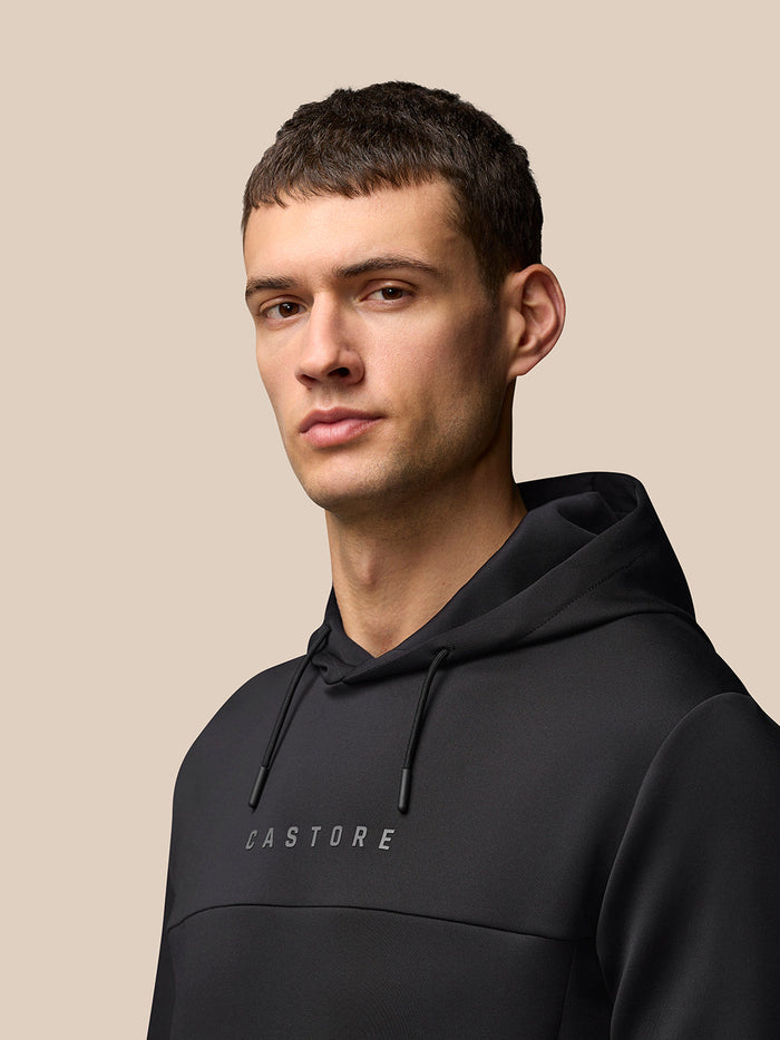 Male model wearing black Flex Hoodie with chest Castore logo.
