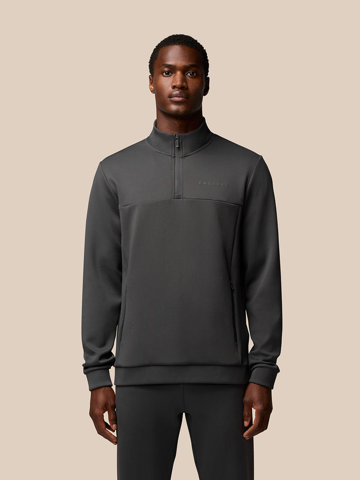 Male model wearing charcoal Flex Sweatshirt with quarter zip and stand collar, Castore branding on left chest