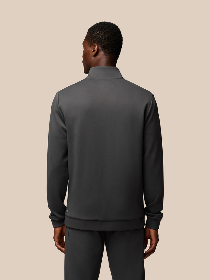 Back view of male model in charcoal Flex Sweatshirt with quarter zip and ribbed hem