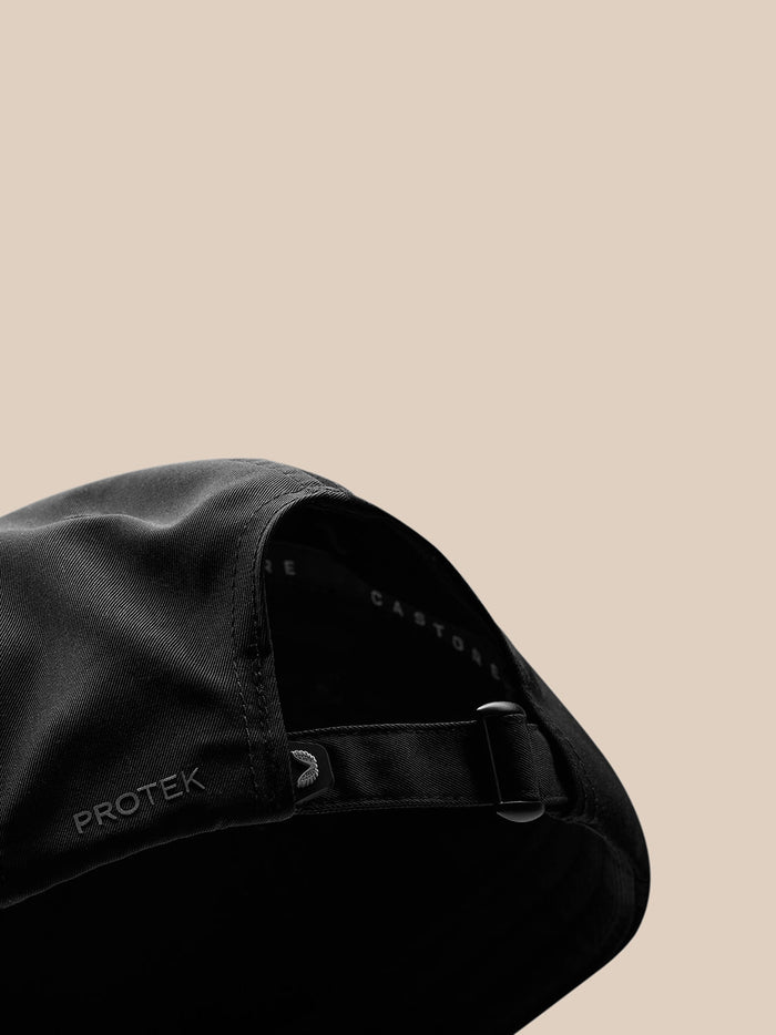 Back view of a black nylon cap with an adjustable strap
