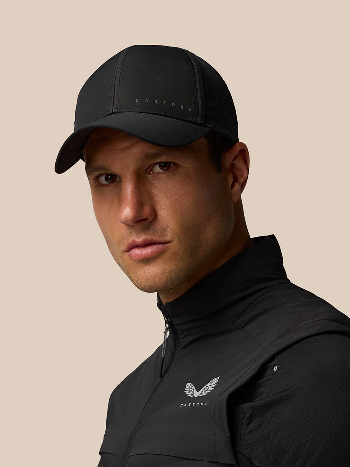 Side profile of a man wearing a black nylon cap with Castore branding on the front.