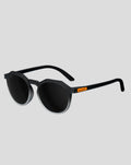 SunGod x McLaren Core Zephyrs sunglasses front three quarter view with black frame round lenses and orange temple badge